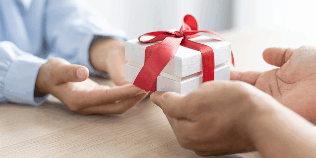 charitable giving, someone handing a mini gift to another