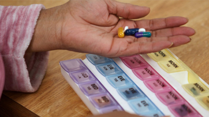 woman-holding-her-pulmonary-fibrosis-related-medications-in-her-hand